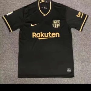 Svart FC Barcelona Nike fotbollströja - Snygg svart FC Barcelona fotbollströja från Nike med guldiga detaljer och loggor. Rakuten-tryck på bröstet, klubbmärke och Nike swoosh i guld. Kortärmad modell i lätt och ventilerande material, perfekt för match eller träning.