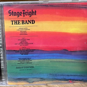 The Band Stage Fright CD - Stage Fright är ett ikoniskt album av The Band, med färgstark omslagsdesign och låtar som 'The Shape I'm In' och 'Stage Fright'. Perfekt för dig som älskar klassisk rock och vill upptäcka legendariska låtar i remastrad version. Bonusspår ingår för extra musikupplevelse!