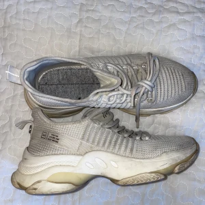 Vita chunky sneakers med stickad ovandel - Säljer ett par vita chunky sneakers från Steve Madden med stickad ovandel och tjock sula. Skorna har snörning och detaljer i syntetmaterial. Perfekta för dig som gillar sportig och modern stil. Snygga att matcha med jeans eller träningskläder. Saknar innesula. 