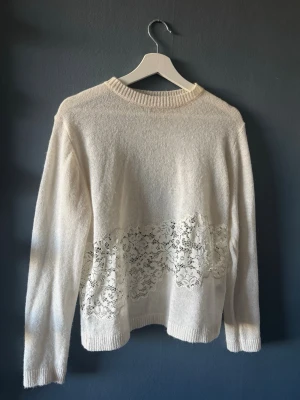 Vit stickad tröja med spets från Zara - Säljer en vit stickad tröja från Zara med rund halsringning och långa ärmar. Använd max 3 gånger💕Storlek M men passar dig som är S! Tröjan har en snygg spetsdetalj över magen och ryggen som ger en unik touch. Perfekt för dig som gillar stilrena plagg med det lilla extra. 