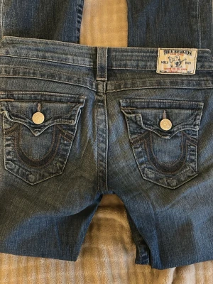 True religion jeans - Ett par jätte snygga true religion jeans som är i storlek 26, osäker på modell men är lite mer mot the ”skinny jeans” hållet men lite utsvängda! Går säkert att sy till bootcut! Super low waist men säljer tyvärr för att jag inte fått användning av dem! Hör av dig vid mått! Syns knappast att det är använda!! Köpt för 700kr