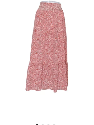 Rosa långkjol med paisleymönster från Zara - Långkjol från Zara i rosa och vitt med paisleyinspirerat mönster. Kjolen har en lätt utsvängd form och är tillverkad i ett mjukt bomullstyg, perfekt för en avslappnad och trendig look.