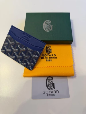 Blå korthållare/plånbok från Go4yard - Snyggt blått kortfodral med klassiskt mönster. Tillverkat i canvas och läder, har flera fack för kort och är perfekt för dig som vill ha en stilren och exklusiv accessoar. Levereras med originalask osv. Skickas samma dag🤗