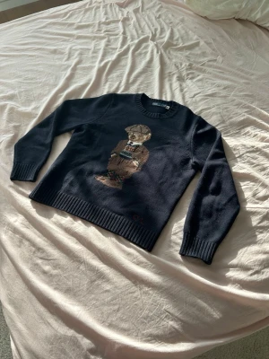 Ralph Lauren polo bear - Säljer denna klassiska Polo Ralph Lauren tröjan med polo bear broderi | Tröjan är i väldigt fin kvalité, utan noppor eller skador! | Storleken är Small och passar perfekt på dig som är runt 175cm | Tröjan är i 90% Ull och 10% Kashmir.