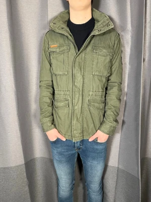 Fieldjacket från Superdry - Snygg fieldjacket från Superdry! Mycket gott skick och inga defekter! Kontakta mig vid minsta fråga! Pris kan diskuteras! //Nils- Storlek L, men passar S