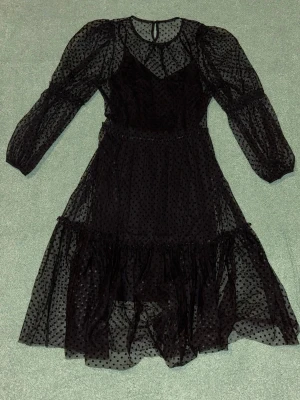 Svart klänning - Svart prickig klänning, samt underklänning. 