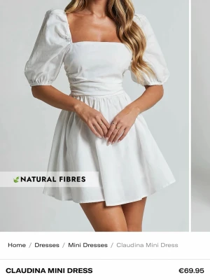 Vit kort klänning med puffärm - Supersöt vit kort klänning med puffärmar och fyrkantig urringning. Klänningen har en markerad midja och ett utställt kjolparti som ger en feminin siluett. Tillverkad i naturligt material, perfekt för varma dagar,skolavslutning eller studenten. Helt ny och oanvänd, prislappen sitter kvar, nypris ca 700kr