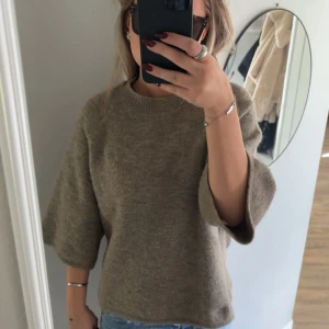 Brun stickad tröja  - Mysig brun stickad tröja från Gina Tricot med rund halsringning och trekvartsärmar. Tröjan har en avslappnad passform och är perfekt att styla med jeans eller kjol. Superenkel och stilren för en chill look. Har använts bara några gånger så i väldigt bra skick 