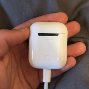 Apple AirPods 1 air pod endast - Apple AirPods (2nd gen) med laddningsetui. Fungerar trådlöst med iPhone och andra enheter. Laddningsfodralet har mindre repor och tecken på normalt slitage, men fungerar som det ska. Perfekt för musik, samtal och smidig anslutning. Tappade andra airpoden i snön förra vintern därför enbart 1