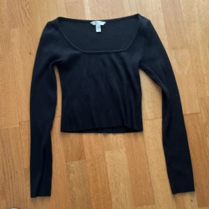 Svart ribbad långärmad topp H&M XS - Svart ribbad långärmad topp från H&M i storlek XS. Toppen har en fyrkantig urringning. Perfekt att styla med jeans eller kjol för en clean look.