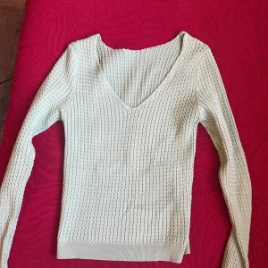 grön stickad v-ringad tröja - Snygg grön stickad tröja med v-ringning och lång ärm. Tröjan har ett strukturerat mönster och ribbade muddar vid ärmslut och nederkant. Perfekt för lager-på-lager och passar till både jeans och kjol.