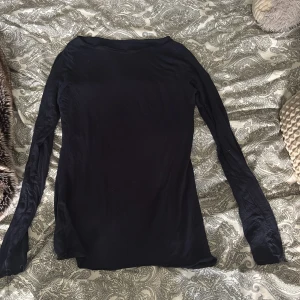 Mörkblå långärmad Intimissimi - En mörkblå långärmad tröja i tunn och mjuk bomull. Modellen är enkel med rund hals och smal passform, perfekt att ha som basplagg. Materialet är stretchigt och känns skönt mot huden. Snygg att styla med jeans eller under en jacka.