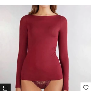 Röd intimissimi tröja - Hålet märks inte. Vinröd långärmad topp med tight passform och rund halsringning. Tillverkad i mjukt bomullsmaterial som sitter skönt mot kroppen. Perfekt att styla med jeans eller kjol för en clean look.