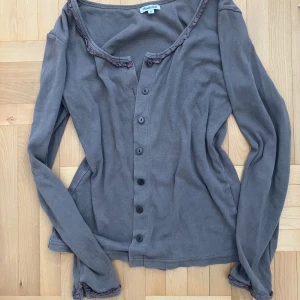 Gråbrun kofta  - Volangdetaljerad bella swan inspirerad kofta. 