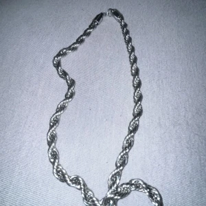Tjockt tvinnat silverfärgat halsband - Säljer ett snyggt halsband med tvinnad kedja i silverfärg. Kedjan har en robust känsla och ett klassiskt repmönster som ger en cool och stilren look. Perfekt för att lyfta din outfit med en enkel men iögonfallande detalj.