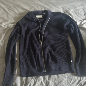 Mörkblå kofta från Jack & Jones - Säljer en mörkblå ribbstickad kofta från Jack & Jones. Koftan har hel dragkedja framtill, långärmad design och klassisk krage. Perfekt för lager-på-lager och chill stil. Materialet är mjuk bomull som känns skönt mot huden. Kom med prisförslag. Nypris 600.