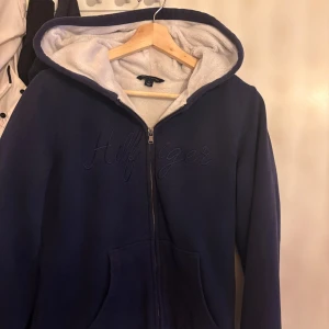 Mörkblå hoodie från Tommy Hilfiger - Snygg tjocktröja från Tommy hilfiger, tröjan är perfekt för kallare dagar. Den är i nyskick