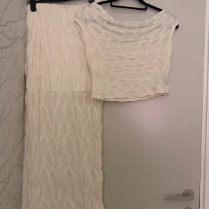 Vit långkjol med strukturmönster - Säljer en vit långkjol med coolt strukturmönster i tyget. Kjolen har en rak passform och är gjord i ett lätt, texturerat material som ger en unik look. Perfekt för dig som vill sticka ut med en stilren men ändå speciell kjol.