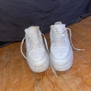 Ett par vita Nike skor - Ett par vita Nike skor som inte har blivit så använda men man ser att de är använda efter som att det är vita.