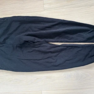 Svarta mjukisbyxor i storlek 170 - Svarta mjukisbyxor med bekväm resår i midjan. Byxorna har en enkel och stilren design, perfekta för en avslappnad look. Tillverkade i mjukt material som känns skönt mot huden. Passar dig som gillar en chill och enkel stil.