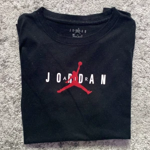 Svart Air Jordan T-shirt - Stilren svart T-shirt från Air Jordan med tryck mitt över bröstet, strl S.