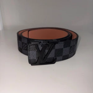 Svart rutig bälte - Svart bälte, 105cm, har en liten missfärg men kan inte synas vid användning.