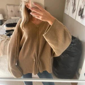 Brun Beige oversized stickad kofta - Säljer en beige oversized stickad kofta med guld detalj och breda ärmar. 