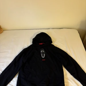 Hugoboss hoodie - Svart hoodie från Hugo med stor huva med ett riktigt fett tryck på ryggen och på bröstet.