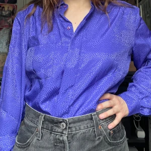 80-tals blus - 80-tals blus med prickar. Även tunna axelvaddar. Jag kan mötas upp i Uddevalla centrum, annars fraktar jag gärna. Köparen står för frakten. (Står ej för postens slarv) katt finns i hemmet. 