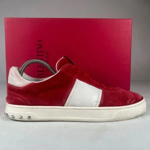Valentino flycrew  sneakers röd/vit mocka - Snygga Valentino flycrew  sneakers i röd mocka med vit läderpanel och vita detaljer. Skon har klassisk låg profil, snörning och platt sula med små nitar baktill. Perfekt för dig som vill sticka ut med exklusiva och trendiga sneakers.