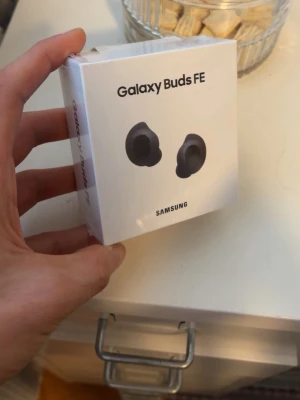 Samsung Galaxy Buds FE trådlösa hörlurar - Samsung Galaxy Buds FE är svarta, trådlösa in-ear hörlurar med aktiv brusreducering och lång batteritid. Snygg och kompakt design, perfekt för musik och samtal. Levereras i originalförpackning.
