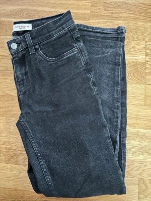 Levi's 502 svarta tapered jeans - Snygga svarta Levi's 502 jeans med regular tapered passform. Klassisk femficksmodell i mjuk bomullsdenim. Jeansen har en mörk tvätt och subtila slitningar för en avslappnad look. Perfekta till sneakers eller boots. Passar dig som är 150/160