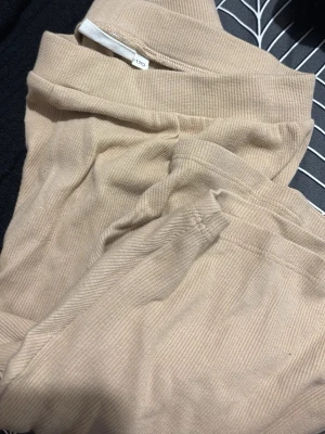 Beige ribbade shorts i bomull - Snygga beige shorts med ribbad struktur och bred resår i midjan. Perfekta för en avslappnad stil och tillverkade i mjuk bomull som känns skön mot huden. Passar dig som gillar enkel och stilren design.