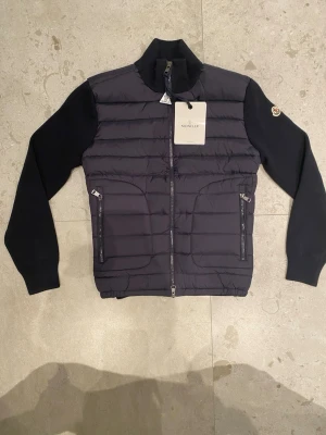 Moncler tricot cardigan  - Hej! Jag säljer här en helt ny Moncler cardigan. Den köptes av en bekant, men visade sig tyvärr vara något för liten för mig. Jag kan inte till 100 % garantera äktheten då jag inte har djupare kunskap om Moncler, men eftersom Moncler Logan går att scanna och jag även har digitalt kvitto, talar det starkt för att plagget är äkta.  Nypris: 10 000 kr Mitt pris: 3 599 kr Storlek: M  Tveka inte att höra av er vid frågor eller funderingar. Med vänliga hälsningar, Stylespotresell
