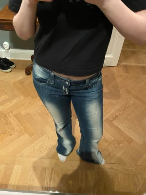 Blå bootcut jeans med slitningar - Snygga blå bootcut jeans med markerade slitningar framtill och baktill från cheapmonday. Jeansen har klassisk femficksdesign och låg midja. Perfekta för dig som gillar en retroinspirerad look med lite extra attityd. Insydda bak i ryggen 