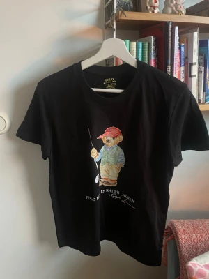 Svart polo bear tröja  - Hjälper nu lillebrorsan att sälja en svart polo bear tröja med coolt fiske motiv. Tröjan har använts väldigt sparsamt, vilket syns på bilderna. Enda tecknet på användning är att texten försvunnit lite (se sista bilden) men påverkar inte tröjan överhuvudtaget. Vid minsta fråga är det bara skriva ett meddelande, mvh! 