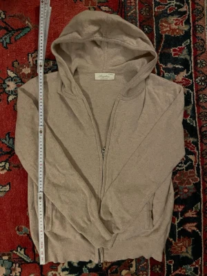 Sayless Hoodie Zip XS – Cashmere - Säljer en eftertraktad Sayless hoodie med zip i storlek XS (sitter true to size). Tröjan är i cashmere av högsta kvalitet och är i perfekt skick utan några defekter.      Modellen på bilderna är 177 cm lång och väger 57 kg. Mått: 	•	Axel till Axel: 43 cm 	•	Midja till Axel: 57 cm (platt mätt)  En lyxig, mjuk och tidlös hoodie som passar perfekt både till vardag och mer uppklädda looks. ⚜️