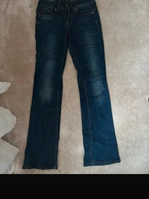 Blå bootcut jeans - Snygga blå jeans med bootcut passform och klassisk femficksdesign. Jeansen har en mörk tvätt och är lite vidare benvidd nertill. (De är mina egna bilder ifrån Vinted som jag råkade radera) storlek 27/34, nypris 1000 kr