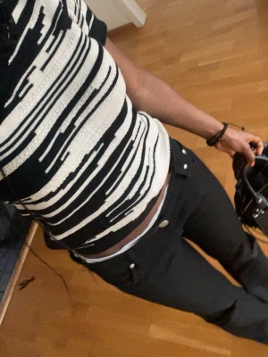 Svarta Victoria Beckham jeans - Säljer ett par svarta jeans med utsvängda ben och synliga knappar framtill. Storlek 27/35 jag är 162 och dom passar perfekt i längden. Man kan säga att det är storlek xs/s. Lite nertrampade där ner (se bild 6) men syns inte på. PRISET GÅR ATT DISKUTERA!!!!