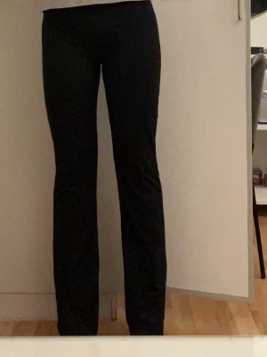 Svarta bootcut leggings - Snygga svarta leggings med bootcut-modell och hög midja. Stretchigt material som sitter bekvämt och formar sig efter kroppen. Perfekta till en avslappnad men ändå trendig look.