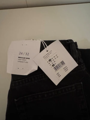 Svarta high waist straight jeans - Snygga svarta jeans med hög midja och raka, vida ben. Klassisk femficksmodell med silverfärgade nitar och knapp. Jeansen har en clean look och är perfekta för en trendig vardagsstil. Storlek 24/32.🙏🏼