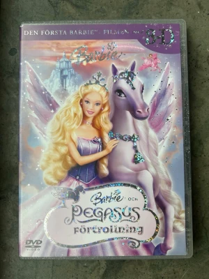 Barbie och Pegasus förtrollning dvd - Barbie och Pegasus Förtrollning på DVD. Innehåller 5 x 3D scener, menyer med röstpålägg av Barbie, Skötsel av Brietta (spel), trailers och Hope har vingar - sång.  Obs! Ingår ej glasögon men gör att kolla på utan :)  Finns på språk: Svenska, Engelska, Finska   OBS!! skivorna är begagnade så det kan förekomma repor/hairlines på skivorna, men då jag kollar igenom alla filmer jag säljer garanterar jag att alla funkar felfritt om inget annat står! :)