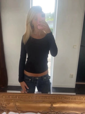 Svart långärmad topp från 157 - En svart långärmad topp från 157 med rund halsringning. Enkel och stilren modell i mjuk bomull, perfekt att matcha med jeans eller kjol. Snygg slim passform som sitter nära kroppen.