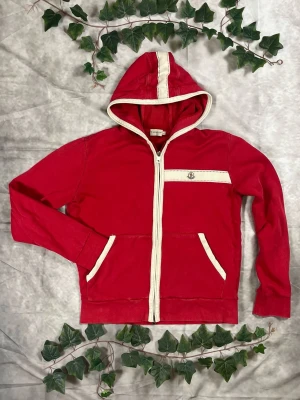 Moncler Maglia Cardigan Zip – Röd – Strl L - "|Färg: Röd, off-white detaljer | Modell: Maglia Cardigan Zip, lätt jacka | Storlek: L, normal passform | Skick: Grade C, 7/10 (2 små hål, missfärgning) | Hör av dig ifall du har funderingar!"