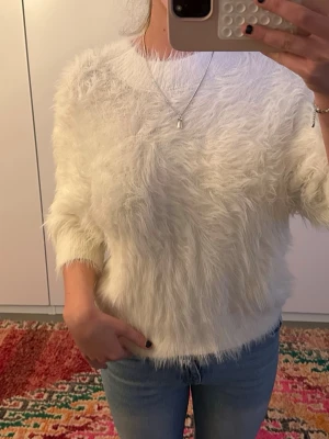 Vit fluffig stickad tröja -  Fluffig vit stickad tröja med trekvartsärmar. 