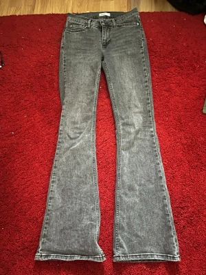 Grå bootcut jeans från Gina Tricot  - Snygga grå bootcut jeans från Perfect Jeans med klassisk femficksmodell och normal passform. Jeansen har en lätt utsvängd siluett nedtill och är tillverkade i mjukt denimtyg som ger en skön känsla. Perfekta för dig som gillar en retroinspirerad look.