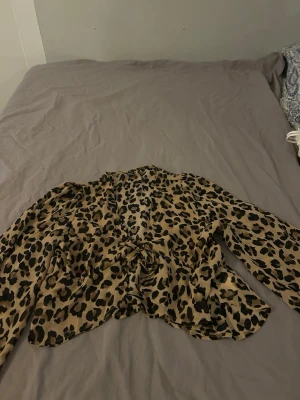 Leopardmönstrad blus med knyt - Säljer en leopardmönstrad blus från shein med v-ringning och knyt framtill. Köpte för ej så länge sen men ej blivit använd 
