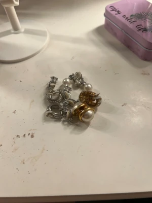 Guldfärgade clipsörhängen med pärla - Säljer ett par snygga clipsörhängen i guldfärg med stor vit pärla i mitten. Klassisk rund form och elegant design, perfekta för att lyfta din stil. Materialet är metall och pärlan är imiterad. Passar dig som vill ha statementörhängen utan hål i öronen.