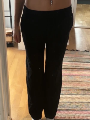 Svarta vida mjukisbyxor - Svarta mjukisbyxor med rak och lite vidare passform. Byxorna har resår i midjan och är perfekta för en avslappnad stil. Sköna och enkla att matcha med olika toppar.