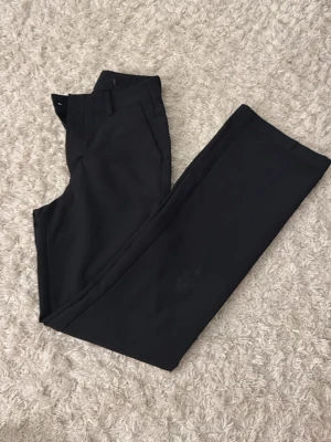 Svarta kostymbyxor från bikbok  - Säljer ett par högmidjade kostymbyxor från BikBok. Jag har sytt upp dom några cm i benen men det går att sprätta upp. Har även sytt in dom i midjan men där går det inte att sprätta upp. Har klippt bor lappen där det står storlek men jag tror att det är xs/34